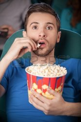 22817396-hombres-en-el-cine-jovenes-emocionados-viendo-la-pelicula-en-el-cine-y-comer-palomitas-.jpg
